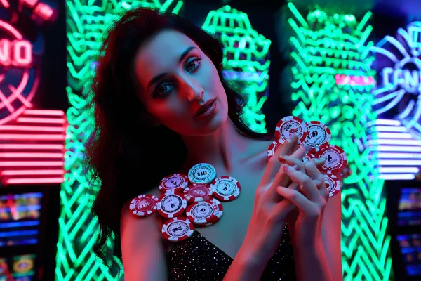 TKPK Slots — Thousands of exciting themes and jackpots A stylish woman beside vibrant slot machines displaying glowing sevens, showcasing the variety of top slots at TKPK.